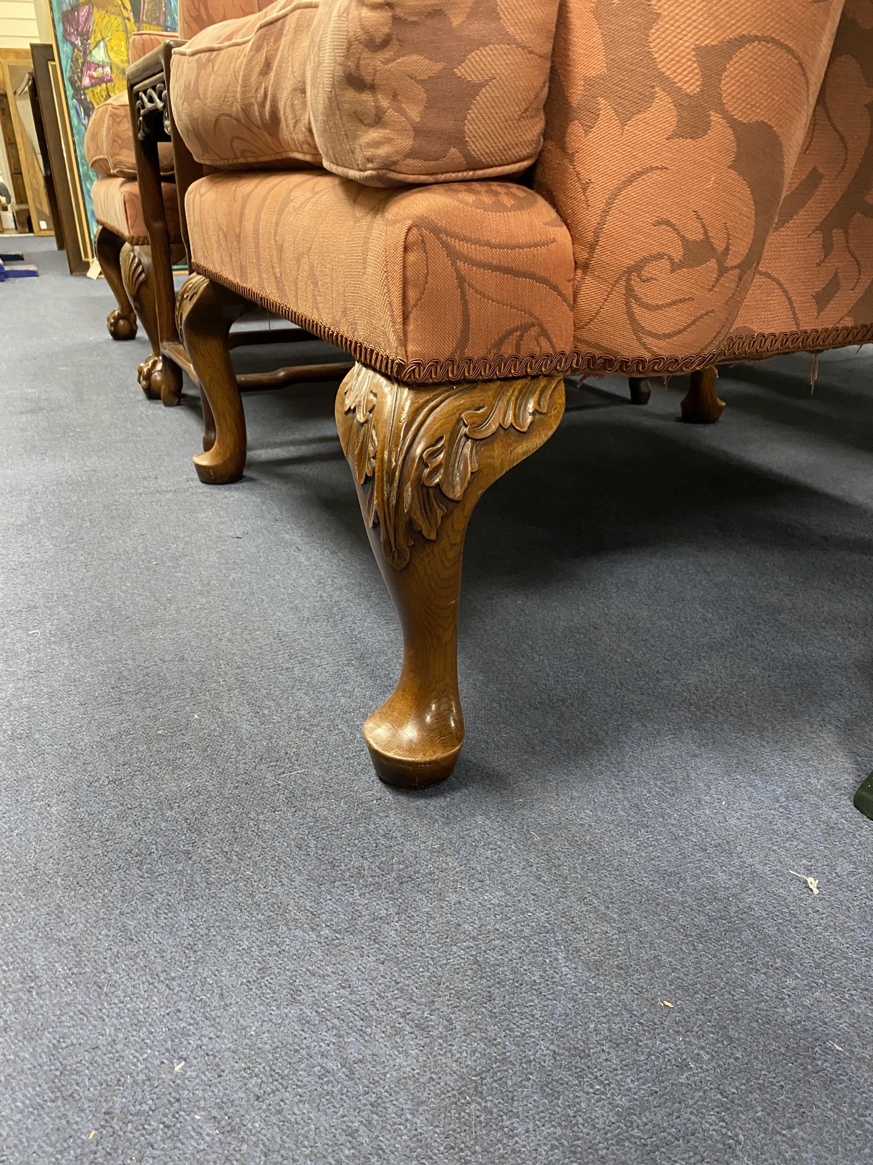 A pair of George I style upholstered wing armchairs on acanthus carved oak feet, width 82cm, depth 86cm, height 124cm